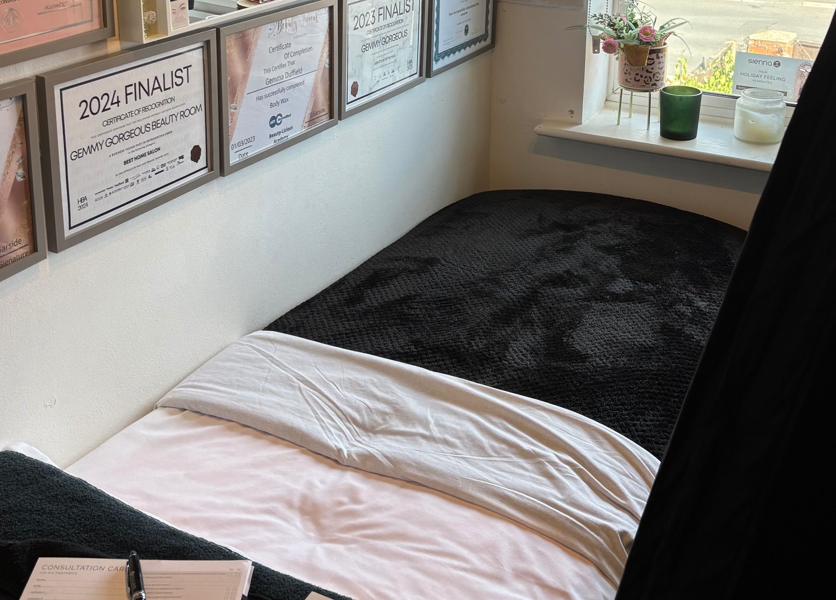 Gemmy Gorgeous in Leeds, England presents a serene beauty treatment room with awards on the wall.