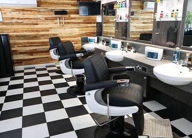 Modern barber chairs in sleek interior of Coal House Cuts, Upminster, England, GB offering premium styling.