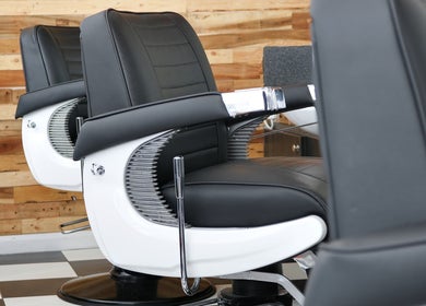 Modern barber chairs at Coal House Cuts in Upminster, England, GB. Sleek and comfortable salon seating.
