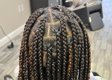 Intricate braided hairstyle at Naturally D’ Fine Beauty in Greensboro, North Carolina, US.