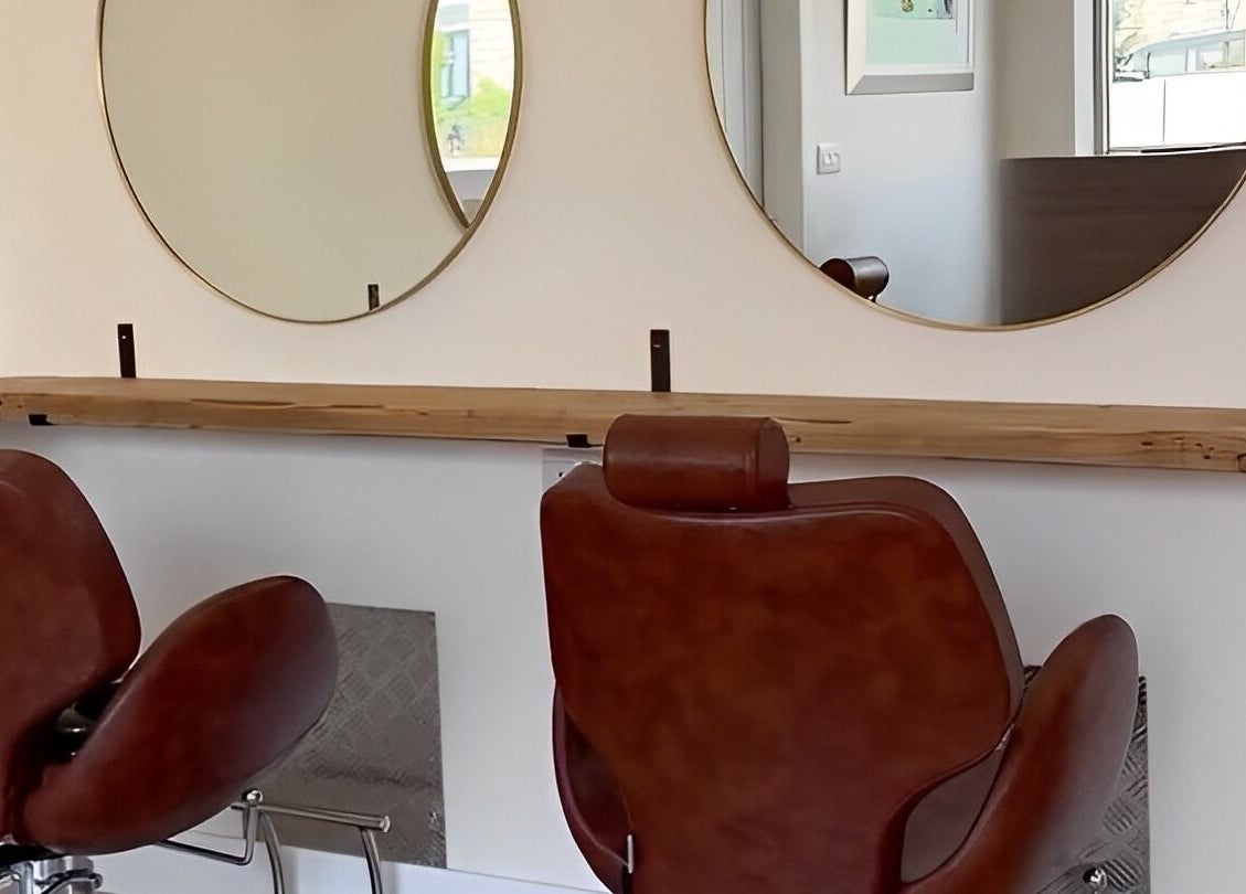 Stylish salon setup at Omor Studio, featuring leather chairs and round mirrors in Wetherby, England, GB.