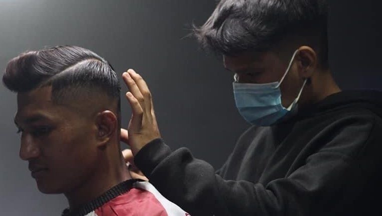 Barber styling a client's hair at Blues Barbershop, Sungai Buloh, Selangor, MY. Modern grooming services in action.