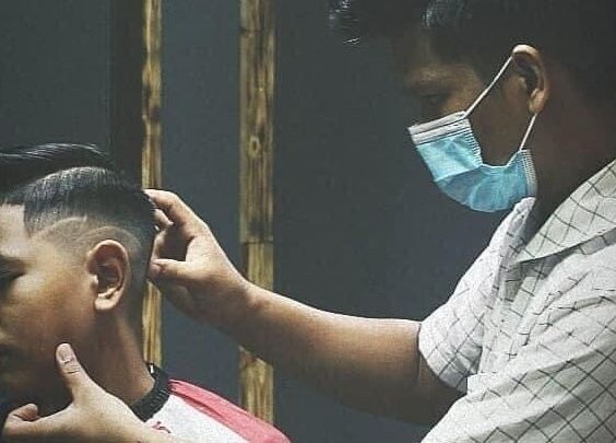 Barber creating a precise haircut at Blues Barbershop, Sungai Buloh, Selangor, MY.