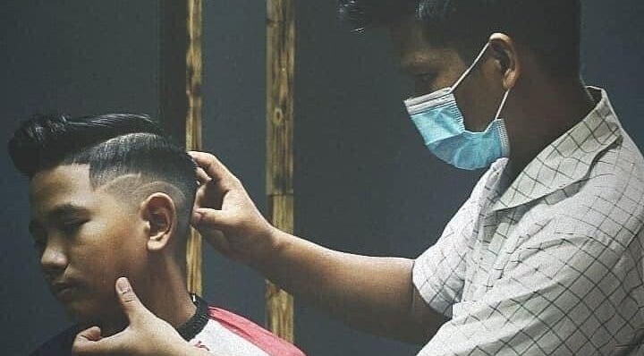 Barber creating a precise haircut at Blues Barbershop, Sungai Buloh, Selangor, MY.