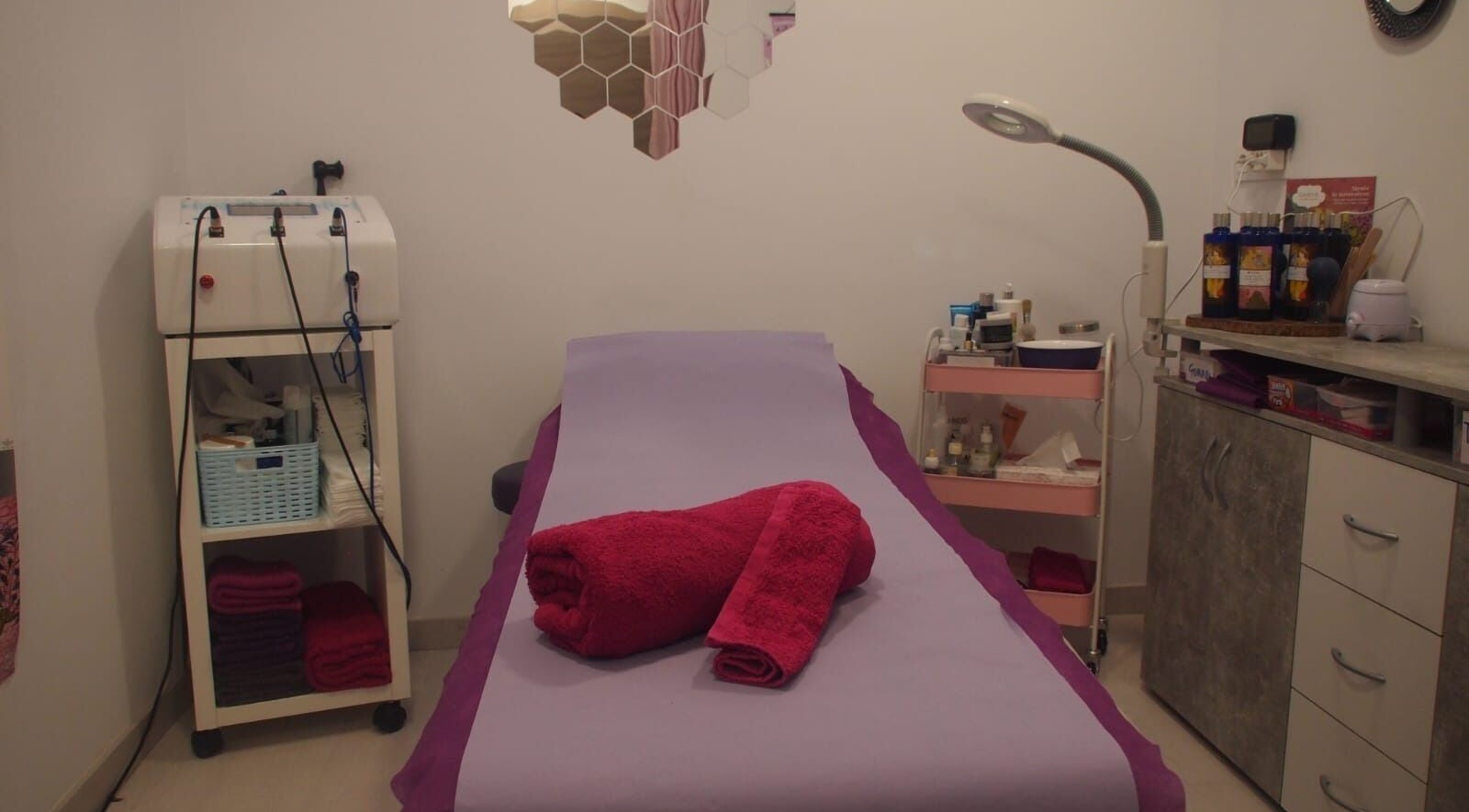 Sala de tratamientos en Dietflash & Nutriconsulta, Badalona, Catalunya, ES. Camilla con toallas rojas y equipo de belleza.