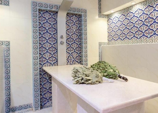 Luxurious spa room at Effect Spa, Dubai, Dubai, AE adorned with intricate blue tile designs and herbal treatments.