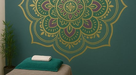 A calming treatment room at In The Zen Tokai, Cape Town, Western Cape, ZA with mandala wall art and massage bed.