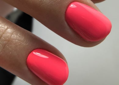 Vibrant pink nails at Ilo Nails.Tech, Worcester, England. Gleaming manicure close-up.