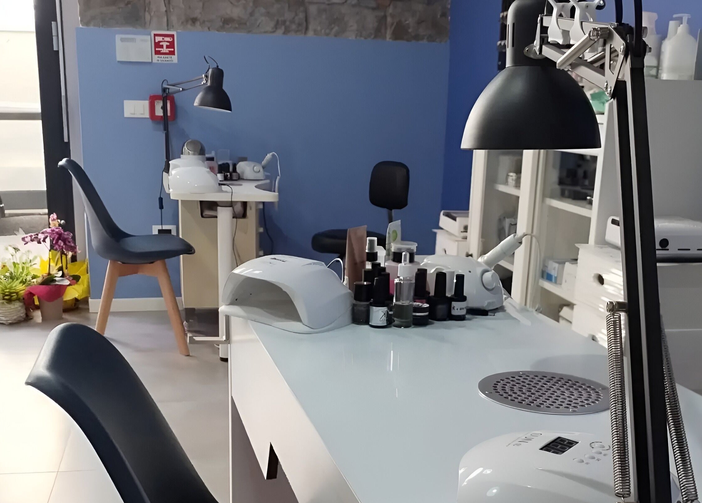 Interno moderno di iobeauty a Trieste, Friuli-venezia Giulia, IT, con tavoli per trattamenti estetici e fiori decorativi.