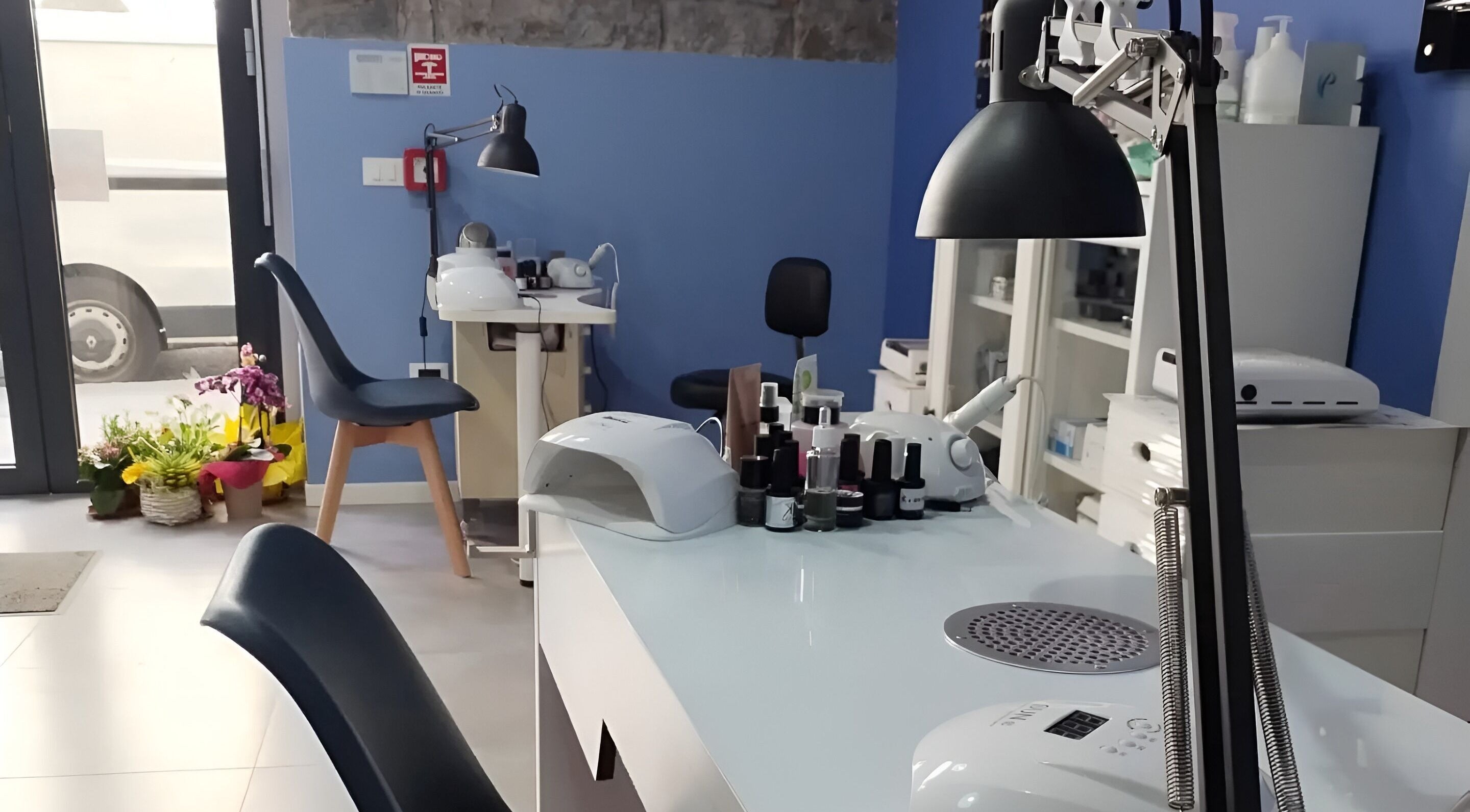 Interno moderno di iobeauty a Trieste, Friuli-venezia Giulia, IT, con tavoli per trattamenti estetici e fiori decorativi.