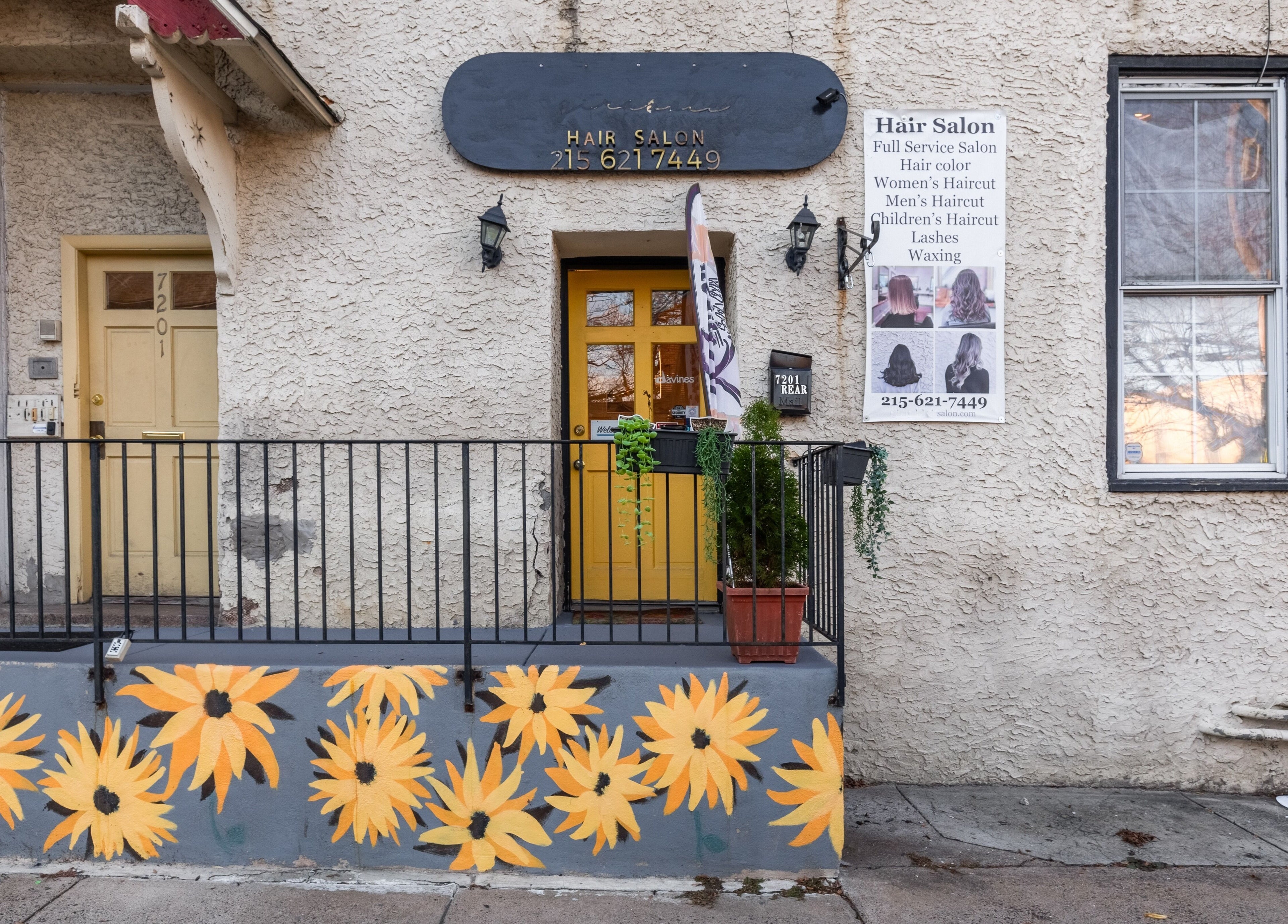 Reppán Centric Salon entrance, Philadelphia, Pennsylvania, US, with sunflower mural and signage.