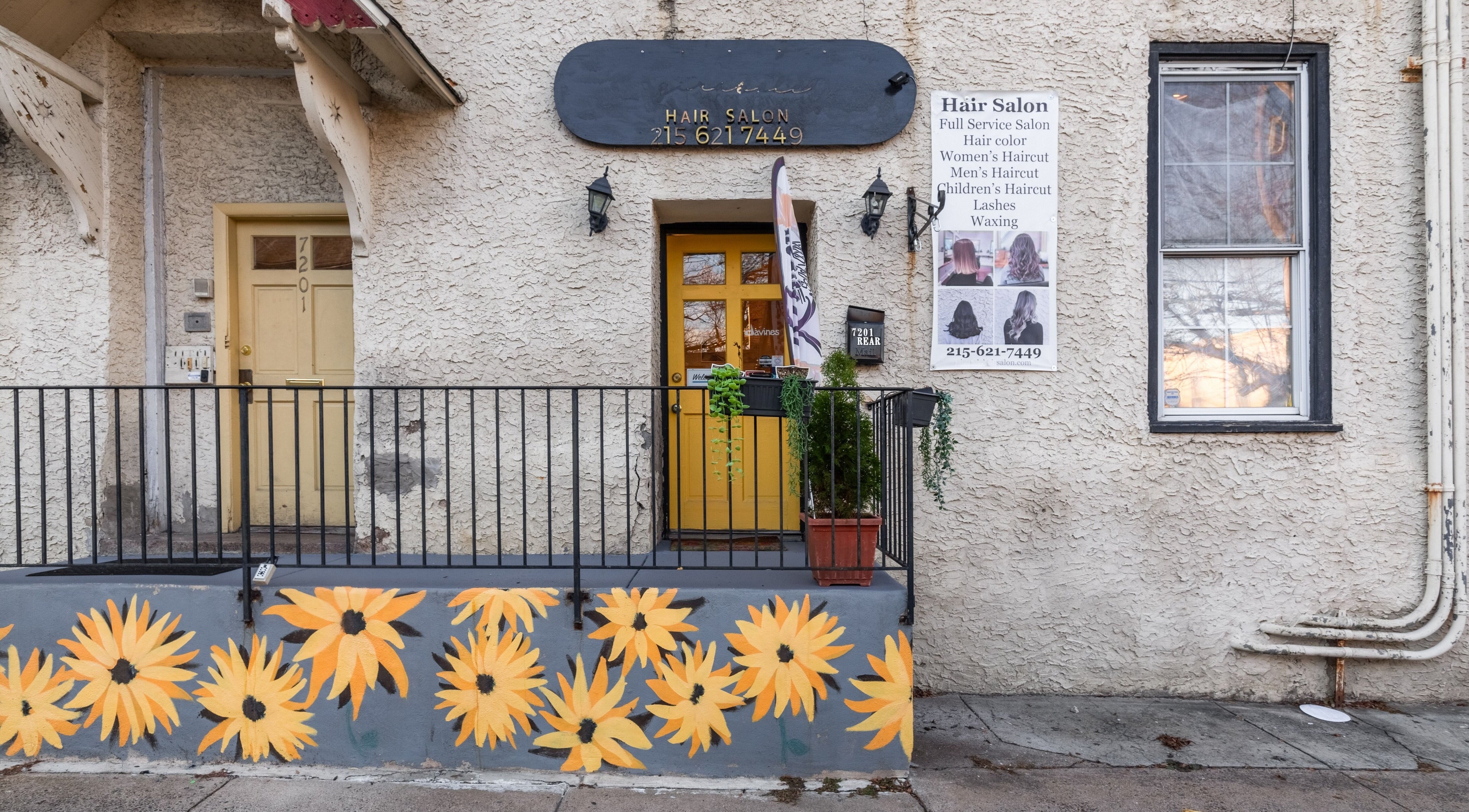Reppán Centric Salon entrance, Philadelphia, Pennsylvania, US, with sunflower mural and signage.