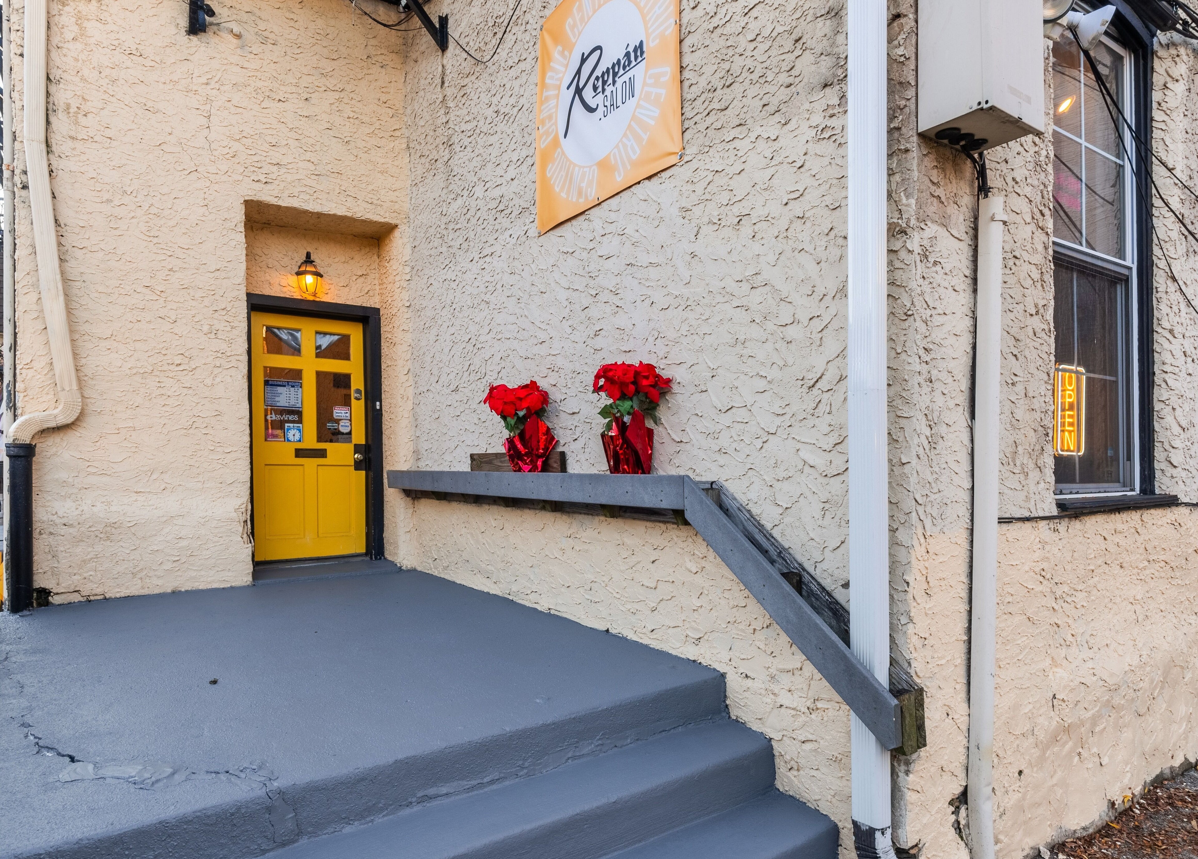 Charming entrance of Reppán Centric Salon in Philadelphia, Pennsylvania, US, featuring a vibrant yellow door.