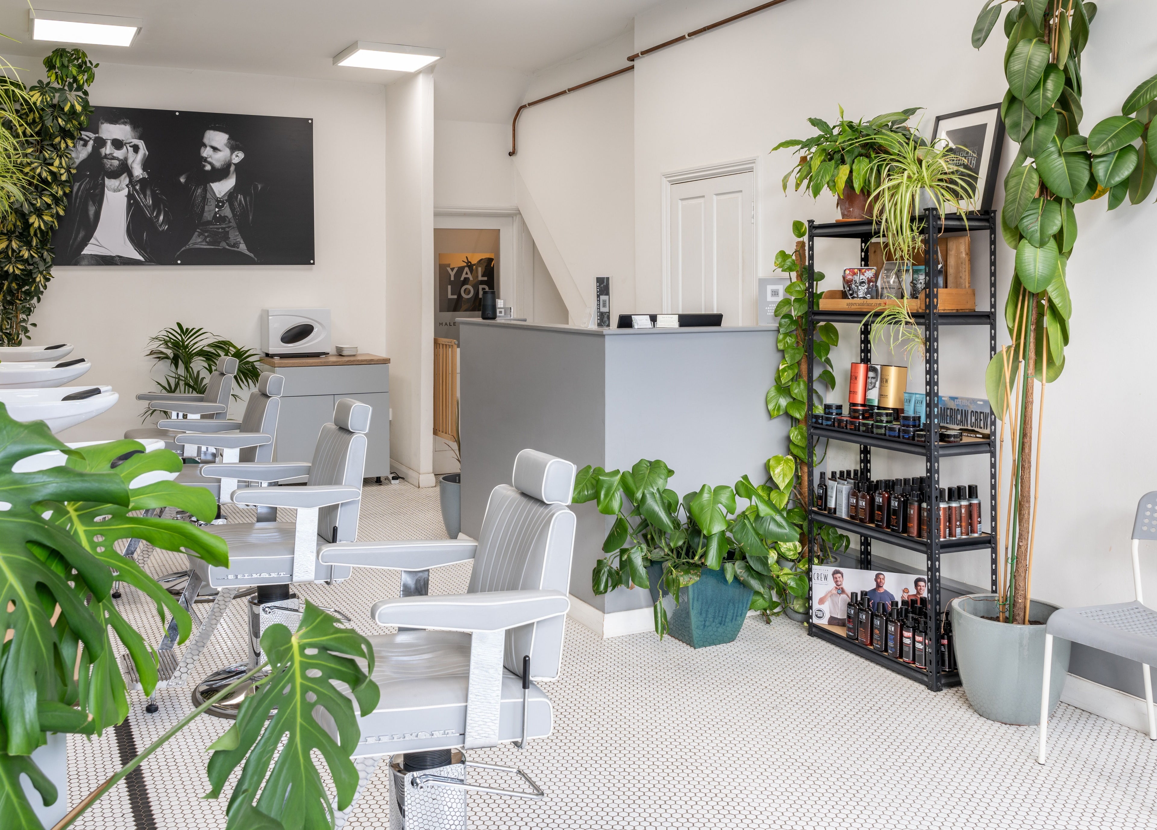 Modern interior of Yallop salon in London, England, GB, featuring sleek styling chairs and lush greenery.