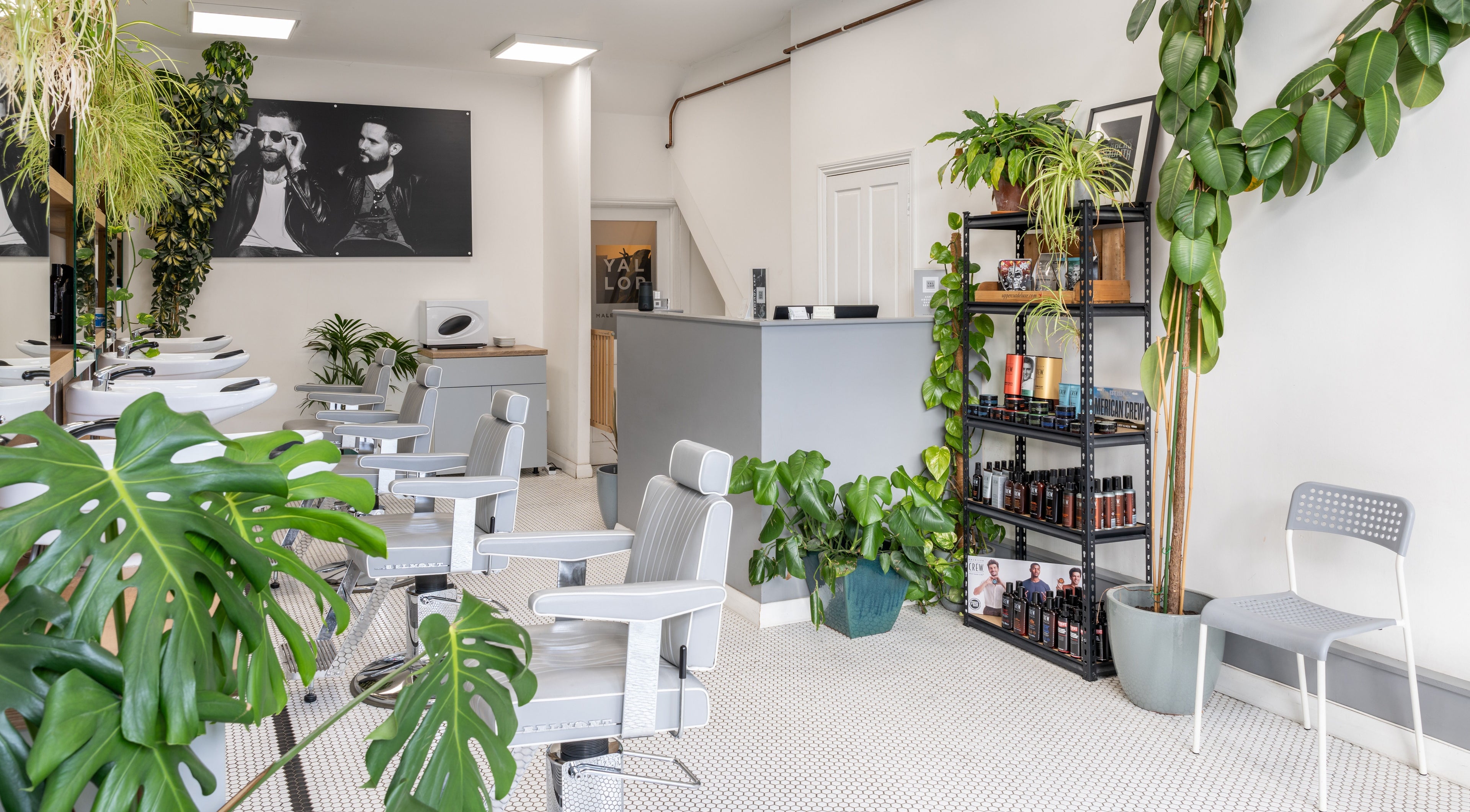 Modern interior of Yallop salon in London, England, GB, featuring sleek styling chairs and lush greenery.