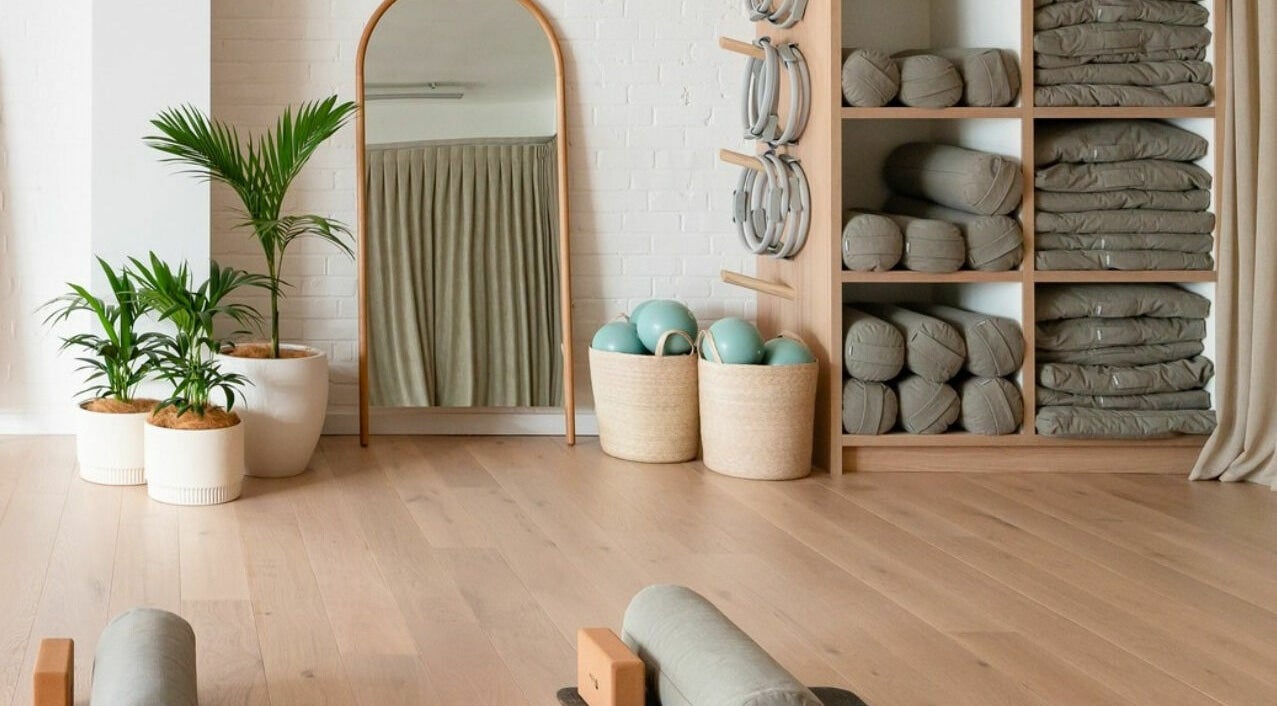 Yoga studio at Well and Being, Dunedin, Otago, NZ with plants, mirror, mats, and props.