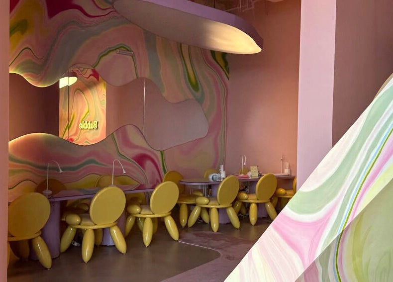 Colorful interior of Bubble in Riyadh, Riyadh Province, SA with vibrant chairs and wavy wall designs.