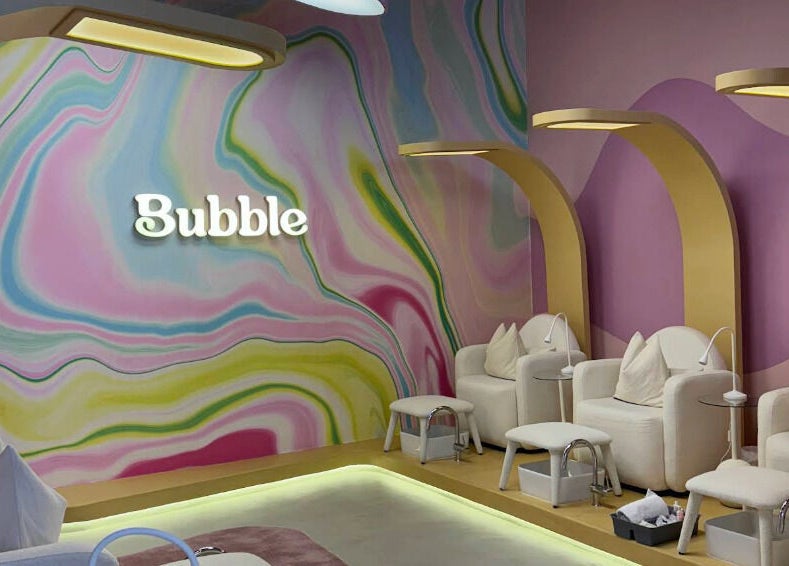 Vibrant seating area at Bubble, Riyadh, Riyadh Province, SA with colorful swirl walls and cozy chairs.