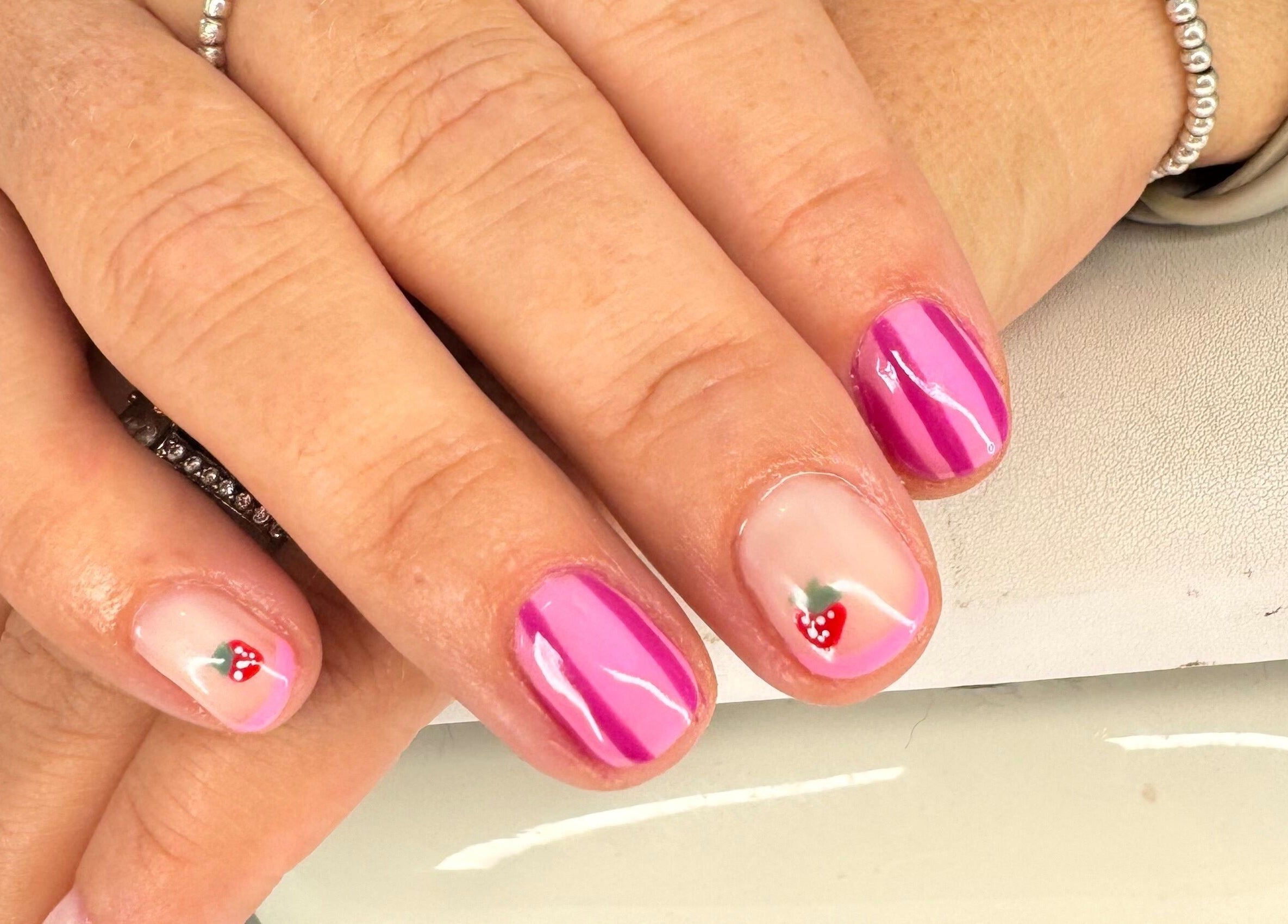 Chic pink nails with strawberry design at Beauty Suite by Annabel, Eastleigh, England, GB.