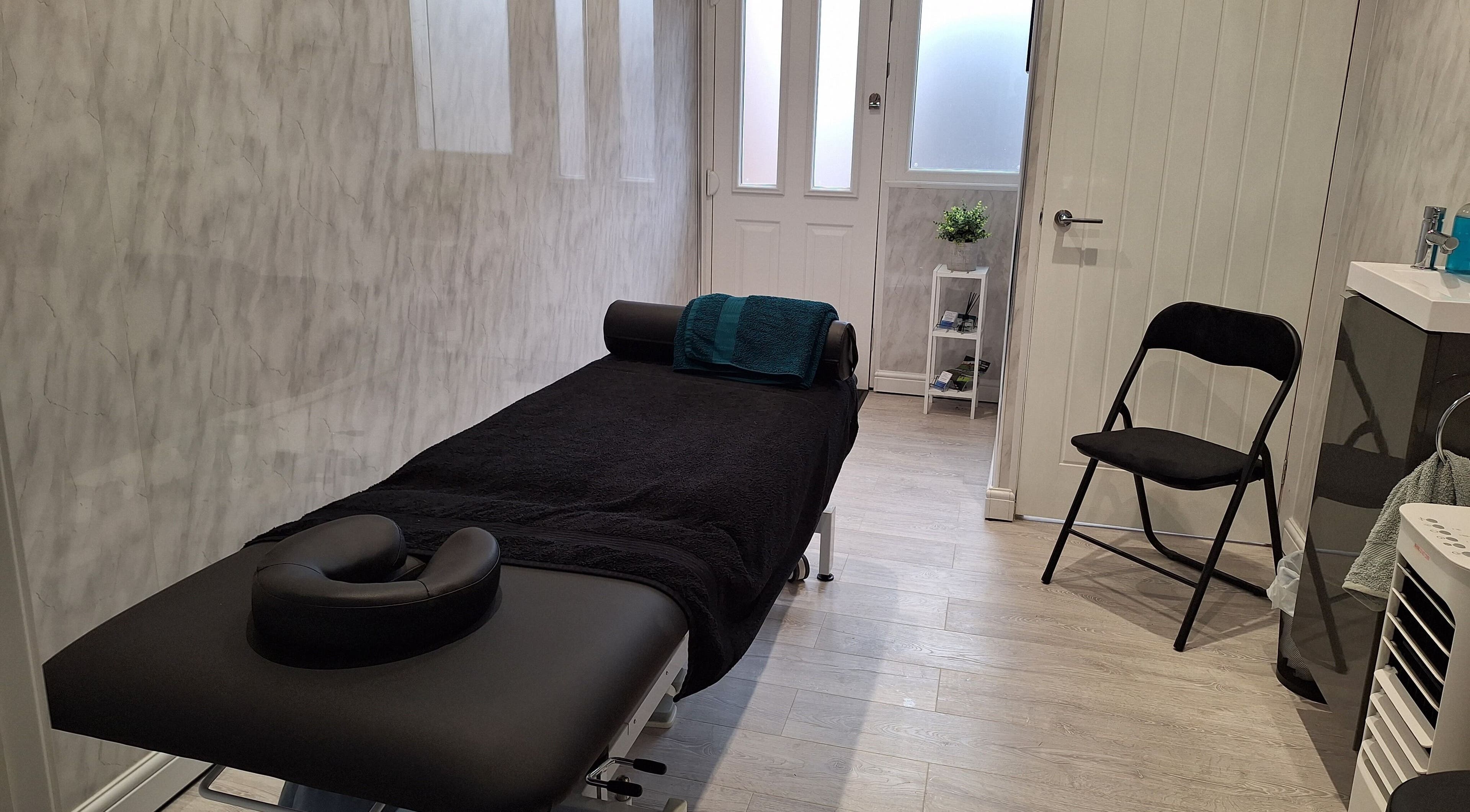Massage room at Gemma Preston Sports Massage, Coventry, GB with a black massage table and simple decor.