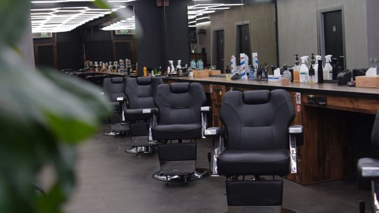 Interior modern al FADE FACTORY POPESTI, Popești-leordeni, România, cu scaune de frizerie negre și elegante.