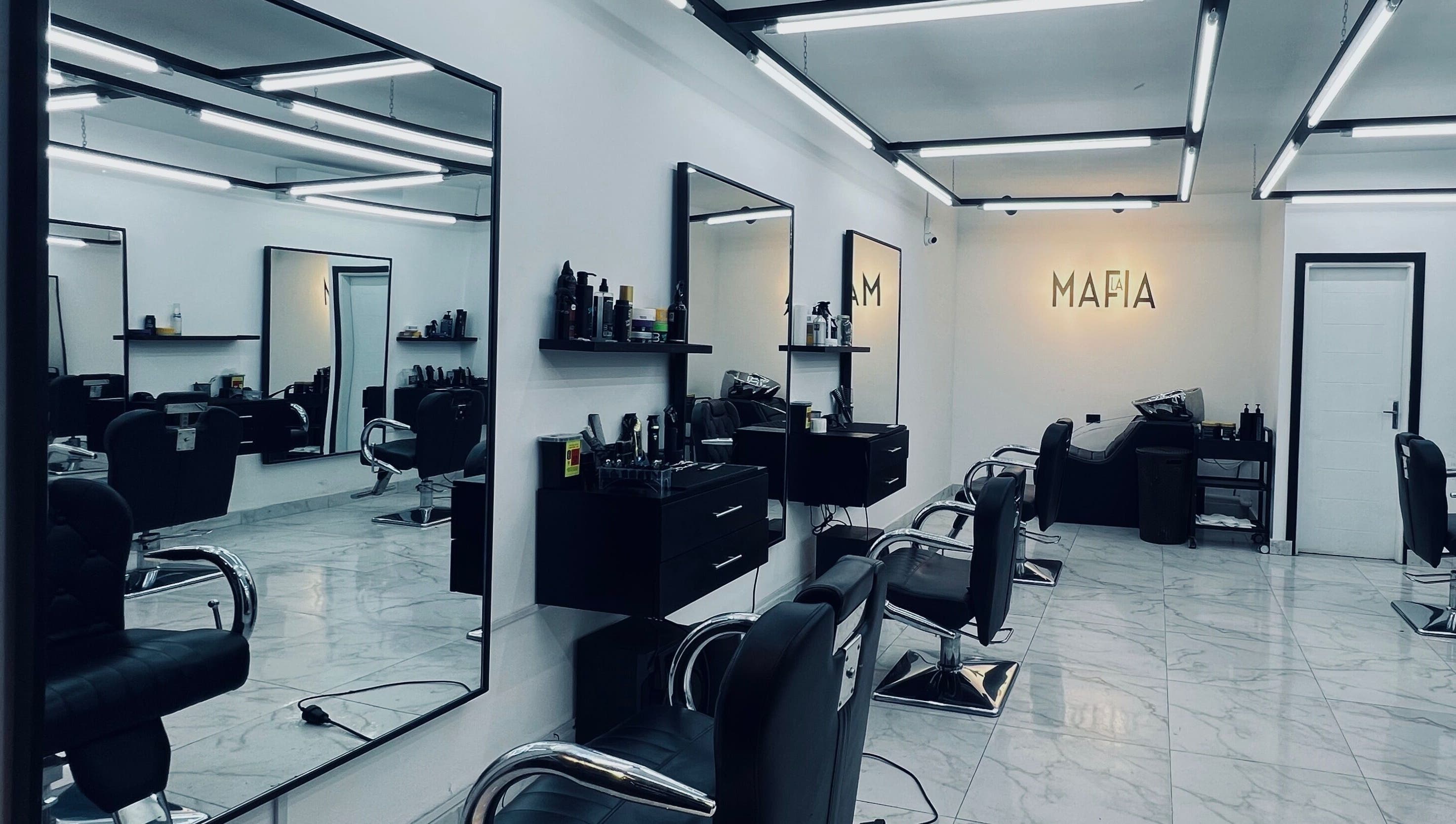 Interior moderno de LA MAFIA - SANTOS DUMONT, Santa Cruz De La Sierra, con sillas de peluquería y espejos.