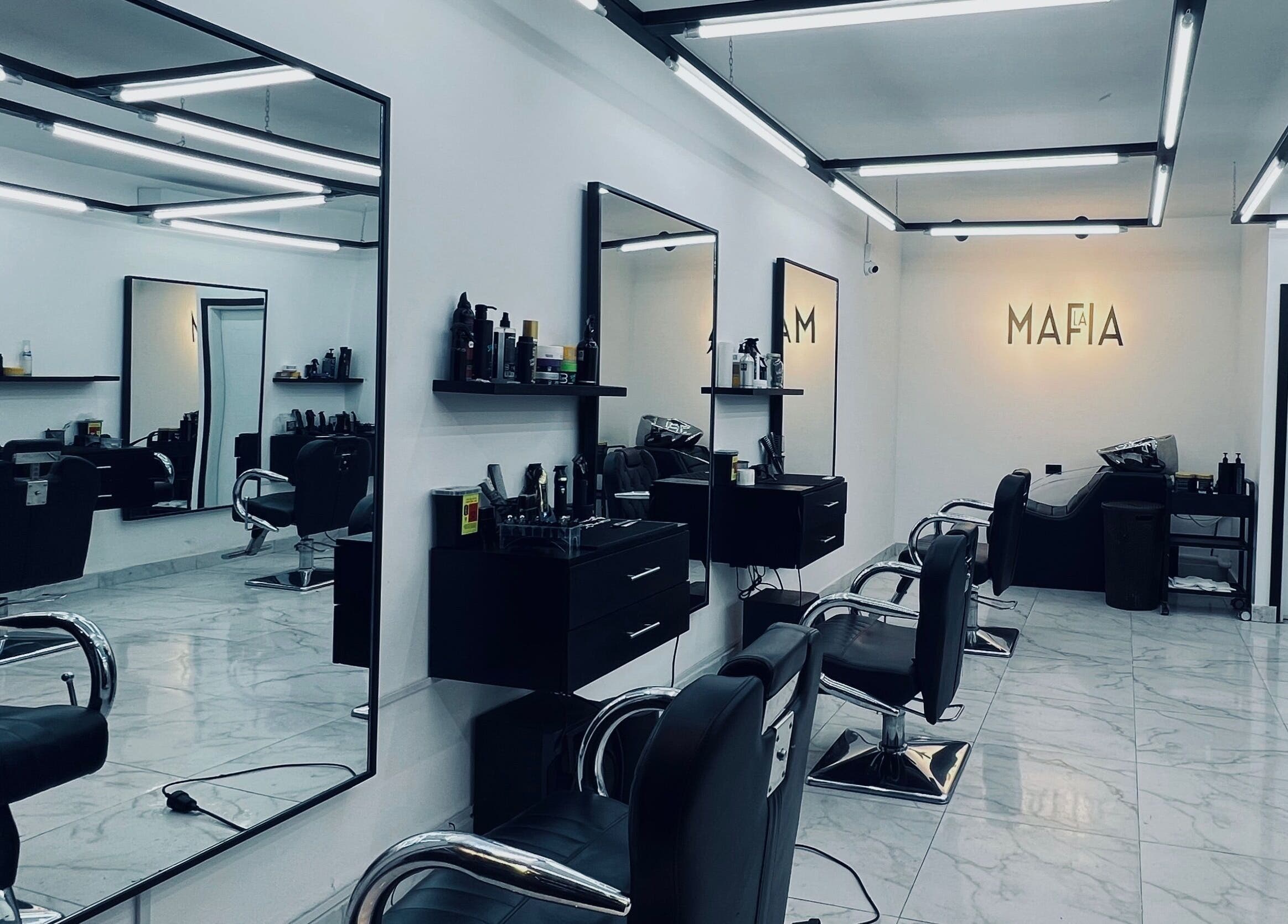 Interior moderno de LA MAFIA - SANTOS DUMONT, Santa Cruz De La Sierra, con sillas de peluquería y espejos.