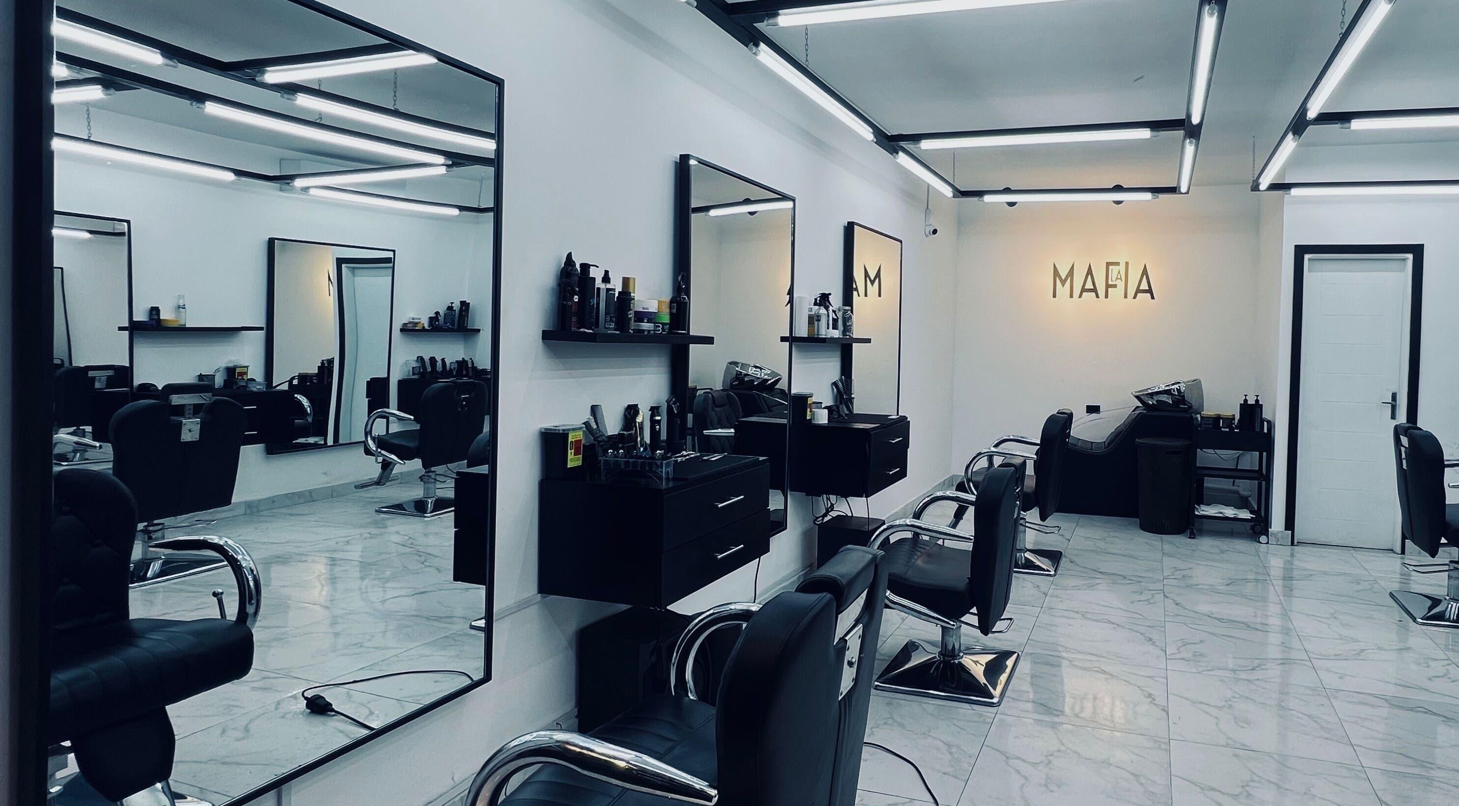 Interior moderno de LA MAFIA - SANTOS DUMONT, Santa Cruz De La Sierra, con sillas de peluquería y espejos.