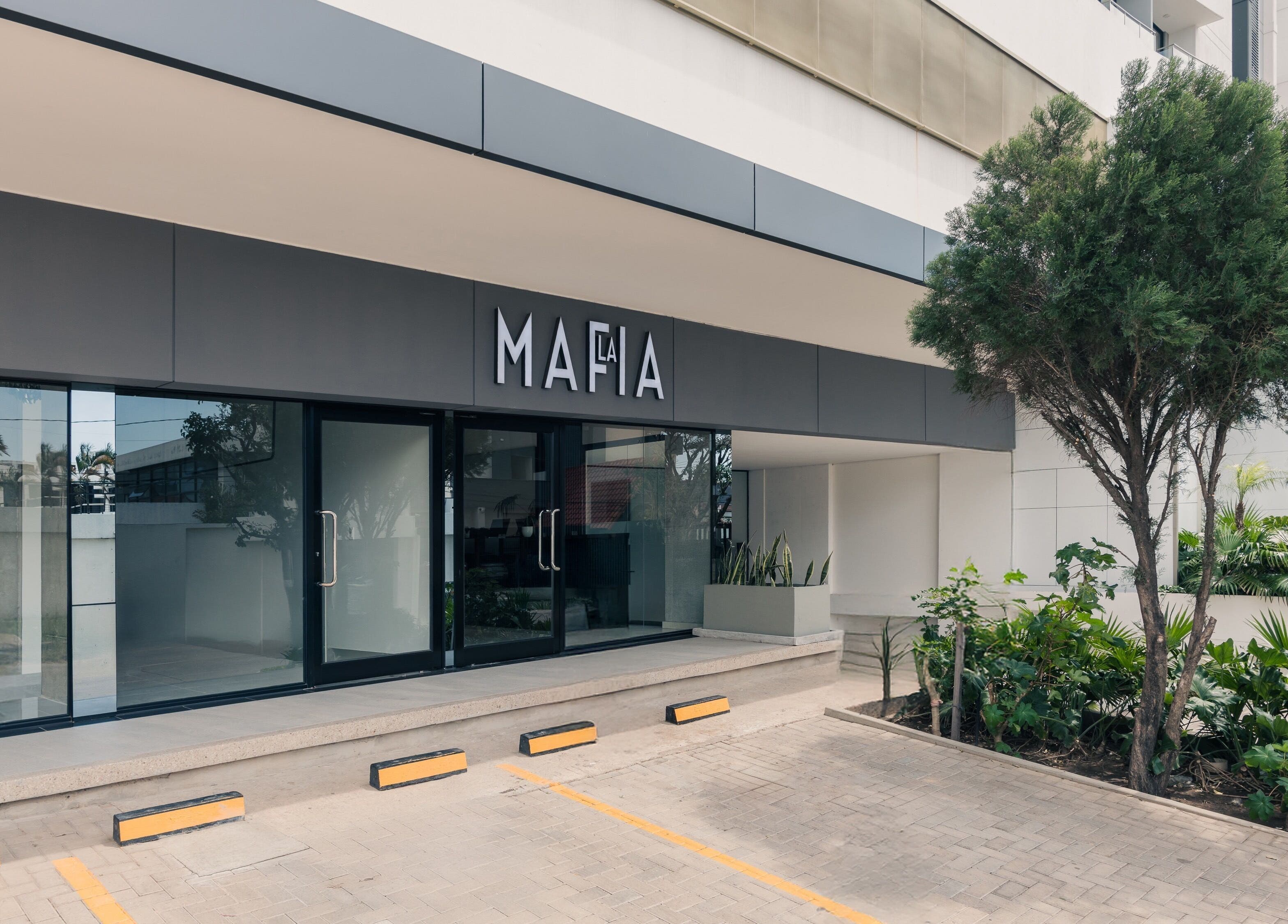 Entrada de LA MAFIA - LOS CUSIS en Santa Cruz De La Sierra, con diseño moderno y vegetación exterior.