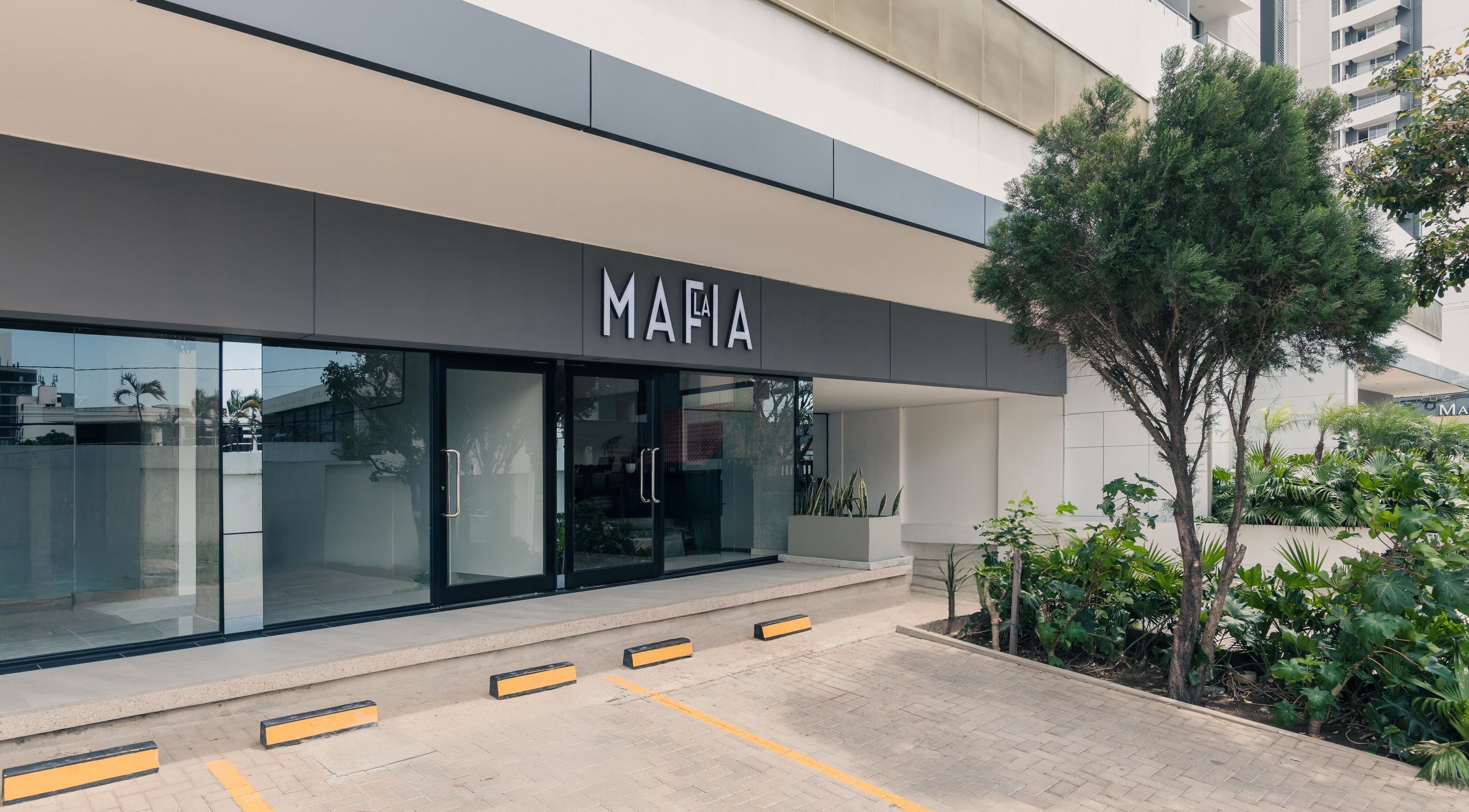 Entrada de LA MAFIA - LOS CUSIS en Santa Cruz De La Sierra, con diseño moderno y vegetación exterior.