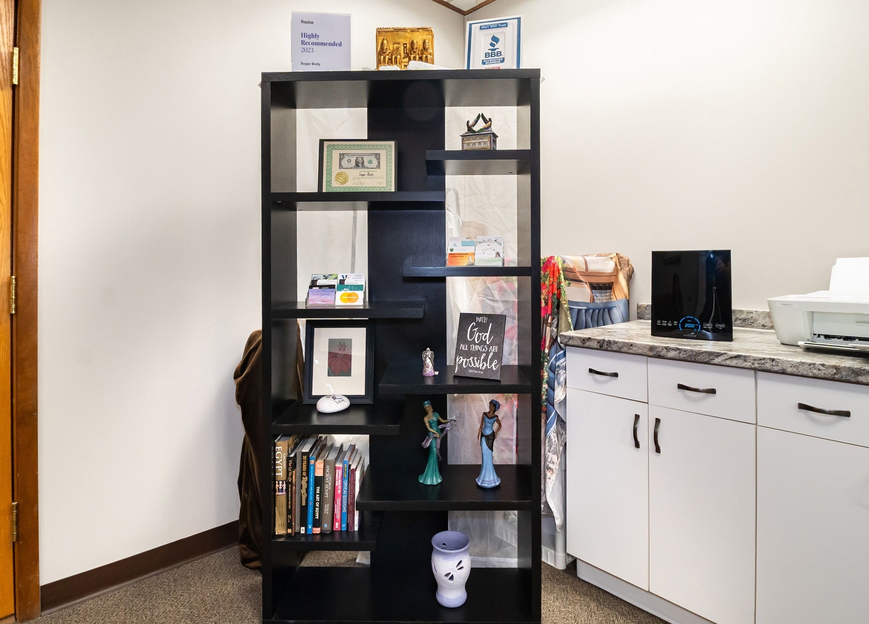 Decorative shelf at Sugar Body Eco-Spa in Buffalo, New York, US, displaying books and artistic decor.
