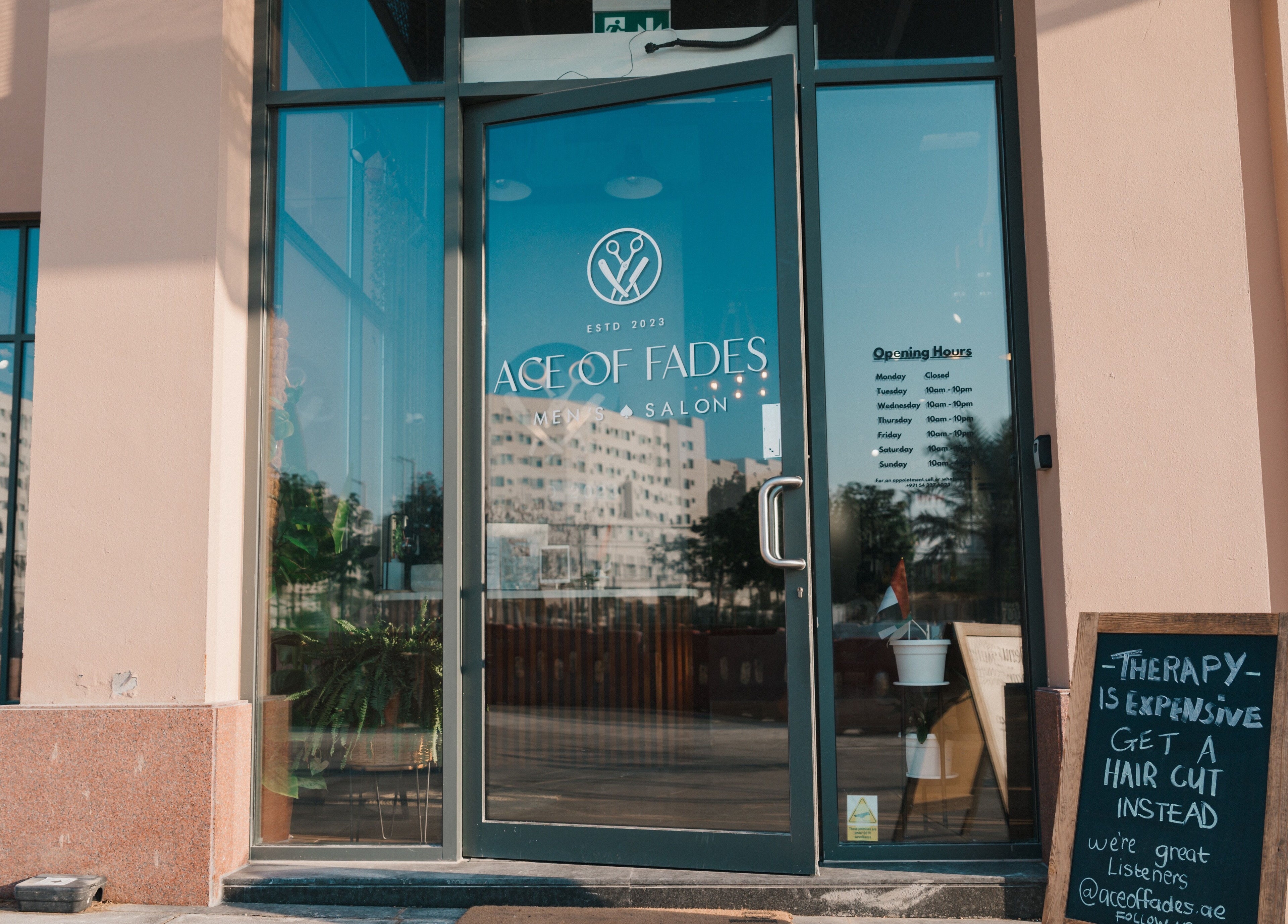 Entrance of Ace of Fades Mens Salon in أبو ظبي, أبو ظبي, AE showing glass door and signboard.