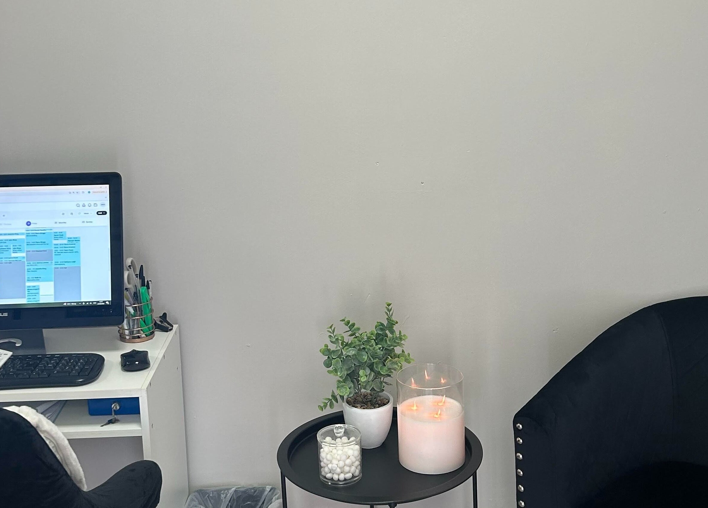 Modern workspace at Adeles Aesthetics and Beauty, Seaham, England, GB, featuring a computer, candle, and plant.