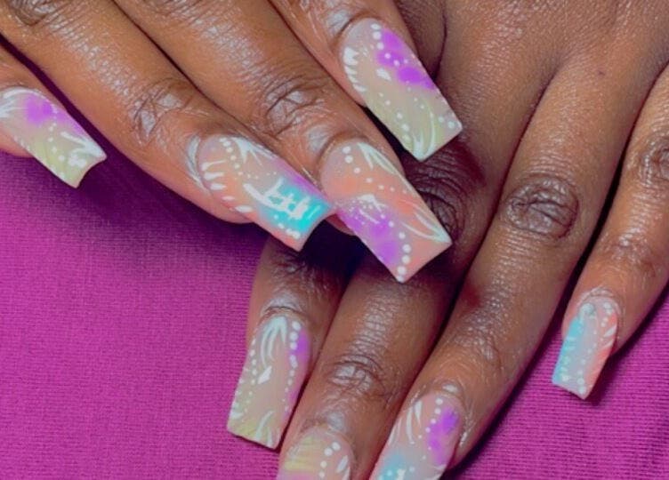 Vibrant nail art design at ChicTips by Rae located in Charlotte, North Carolina, US, on colorful backdrop.