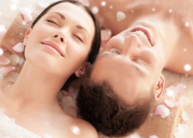 Couple enjoying a relaxing massage amidst rose petals at Body & Soul Massage, Clearwater, Florida, US.