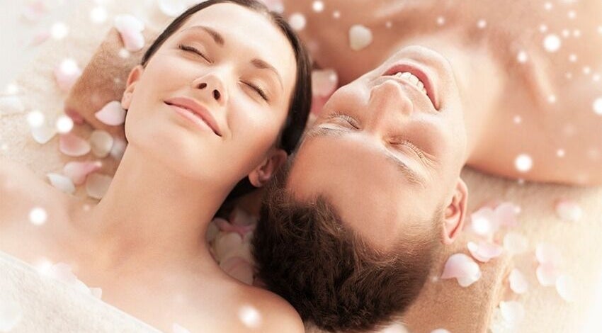 Couple enjoying a relaxing massage amidst rose petals at Body & Soul Massage, Clearwater, Florida, US.