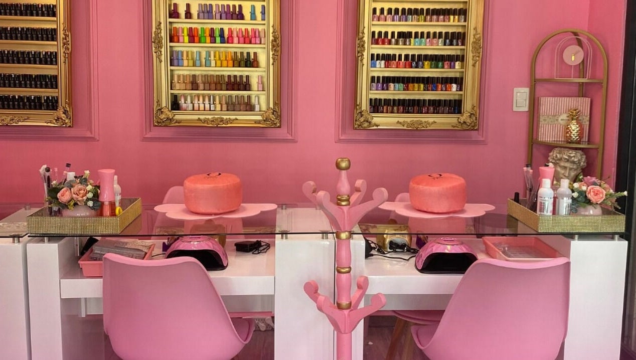 Mesas de manicura en Oh La Lab, Ojo De Agua, Estado De México, MX, con estantes de esmaltes de colores.