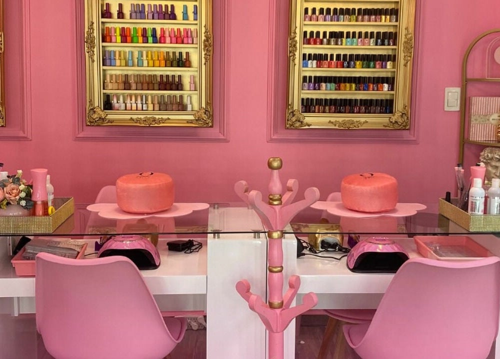 Mesas de manicura en Oh La Lab, Ojo De Agua, Estado De México, MX, con estantes de esmaltes de colores.