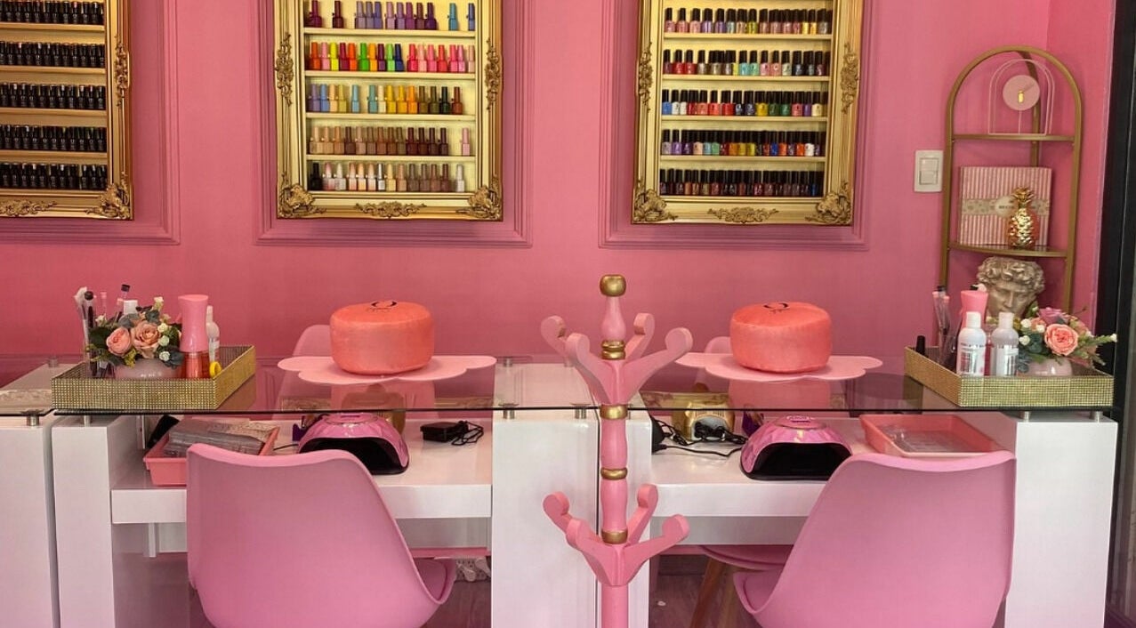 Mesas de manicura en Oh La Lab, Ojo De Agua, Estado De México, MX, con estantes de esmaltes de colores.