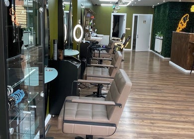 Modern interior of Stevostyle Hair Beauty in London, England, GB with stylish chairs and green accents.