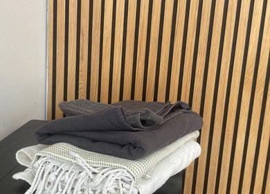 Stacked dark and white towels at Purl Massage Therapy Southside, Glasgow, Scotland, GB.