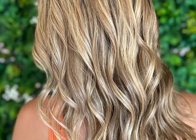 Blonde wavy hair styled at Styles By Margarita, Green Bay, Wisconsin, US with lush natural backdrop.