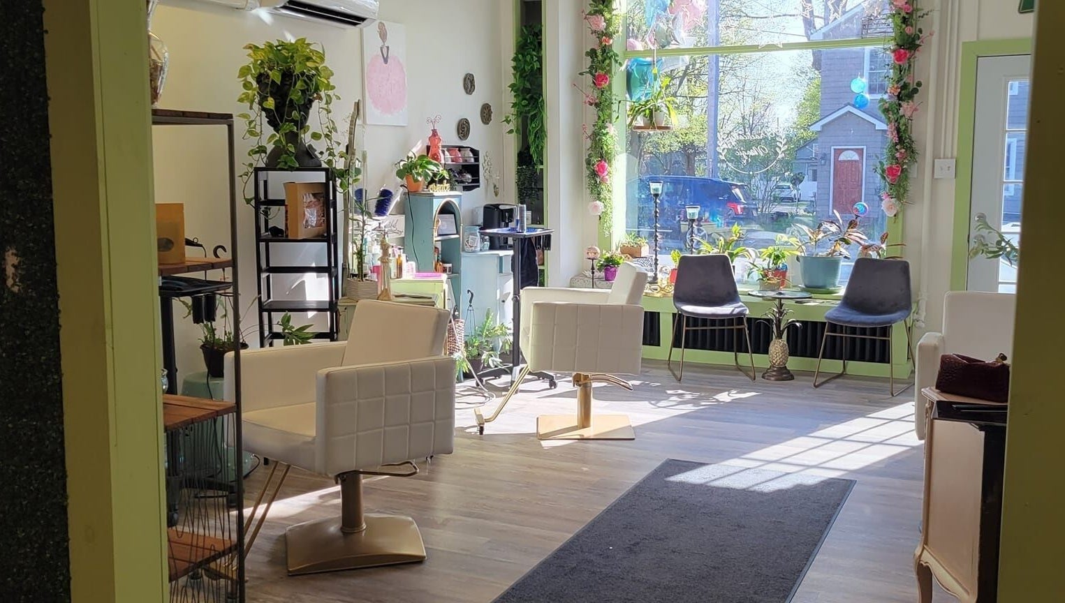 Bright salon interior at Practically Magic, South Glens Falls, New York, US with modern chairs and plants.