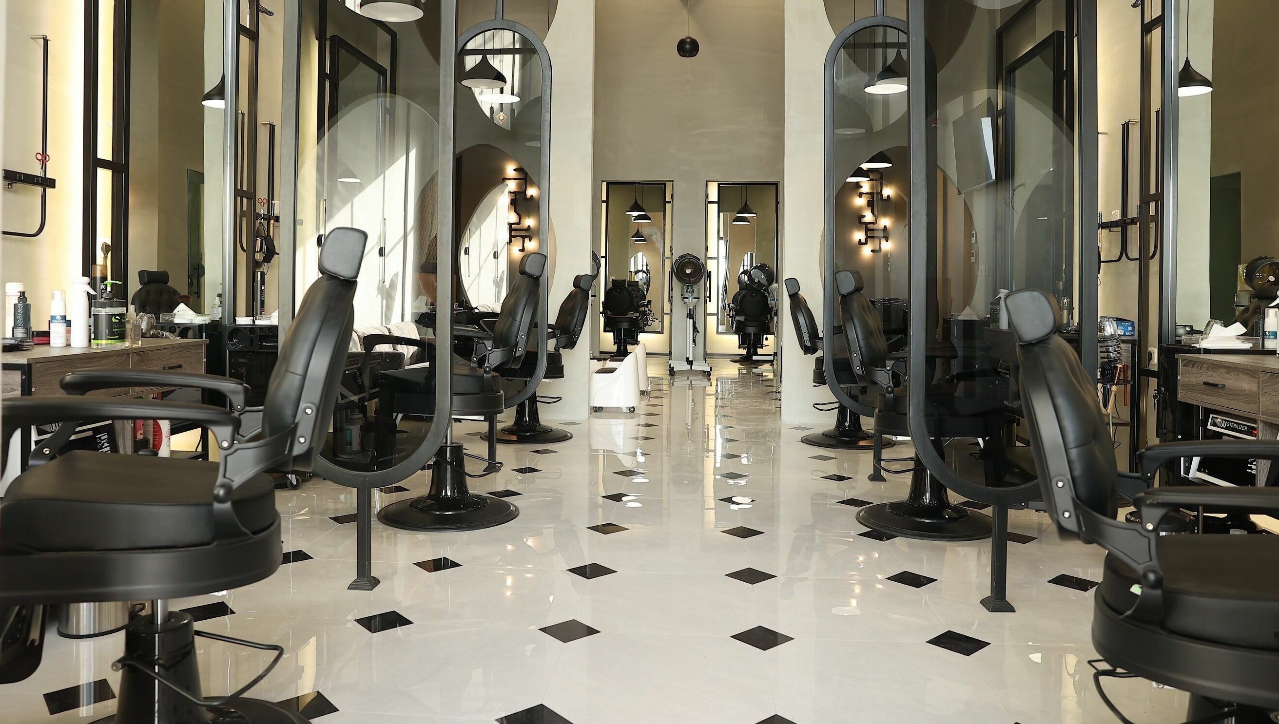 Interior of Mirror Barbershop in Riyadh, featuring modern black chairs and mirrors.