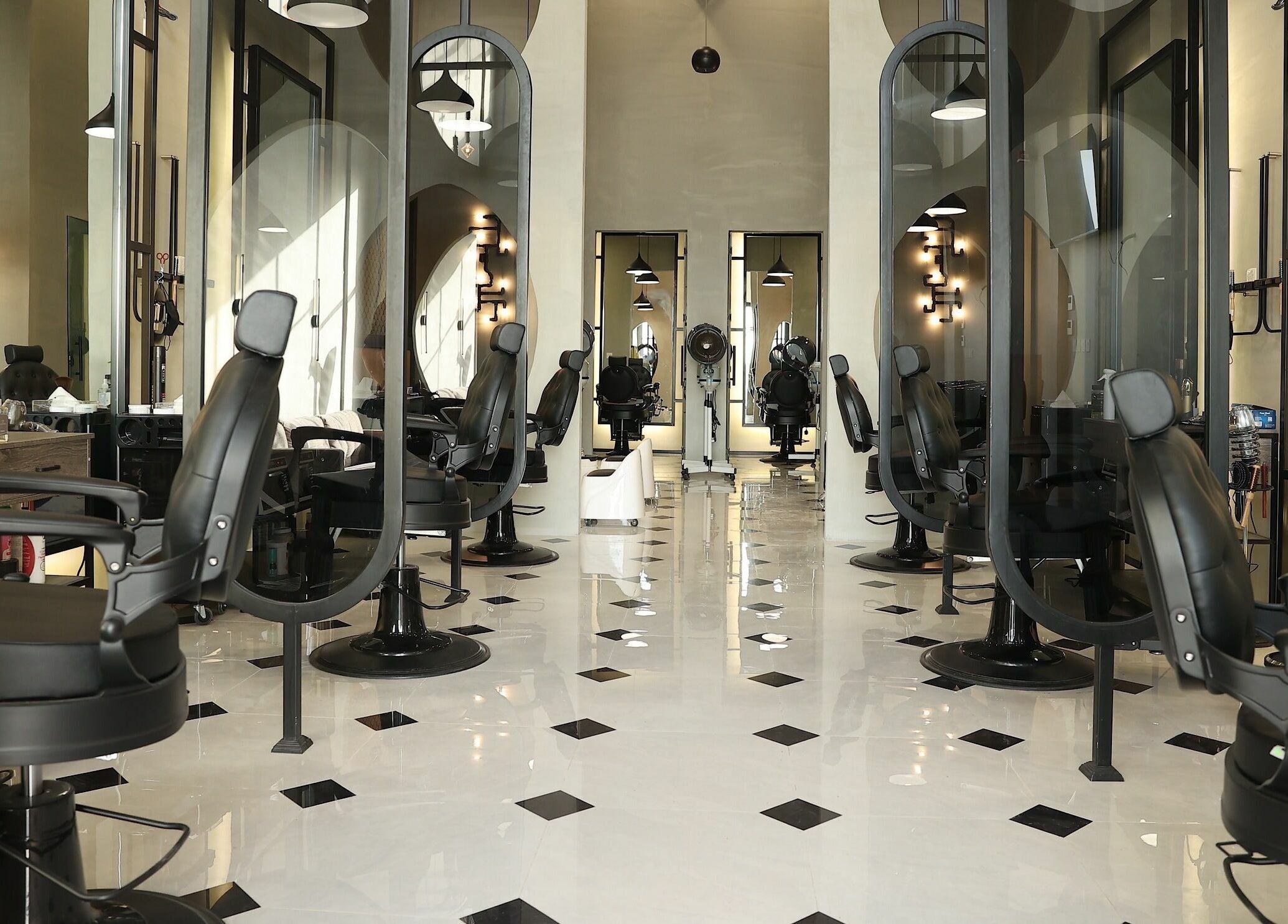 Interior of Mirror Barbershop in Riyadh, featuring modern black chairs and mirrors.