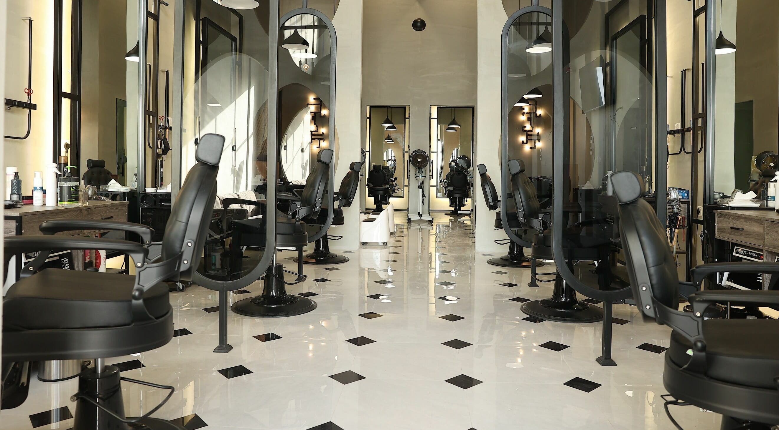 Interior of Mirror Barbershop in Riyadh, featuring modern black chairs and mirrors.