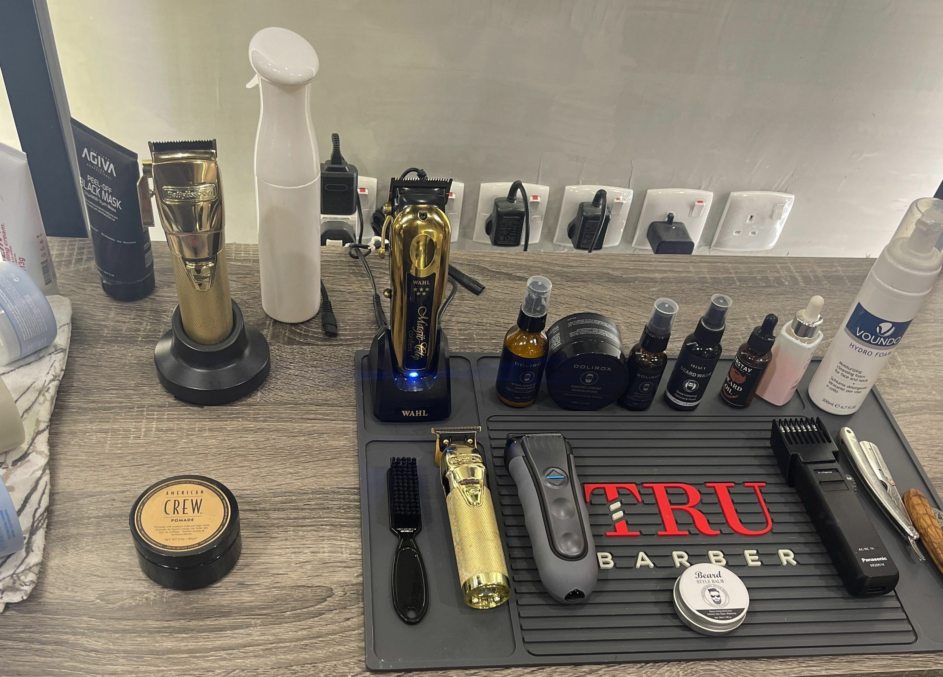 Barber tools and products at Mirror Barbershop, Riyadh. Clippers, creams, and sprays neatly arranged on counter.