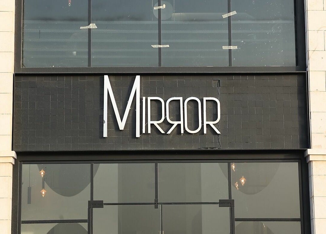 Entrance of Mirror Barbershop in Riyadh, Riyadh Province, SA with modern black signage.