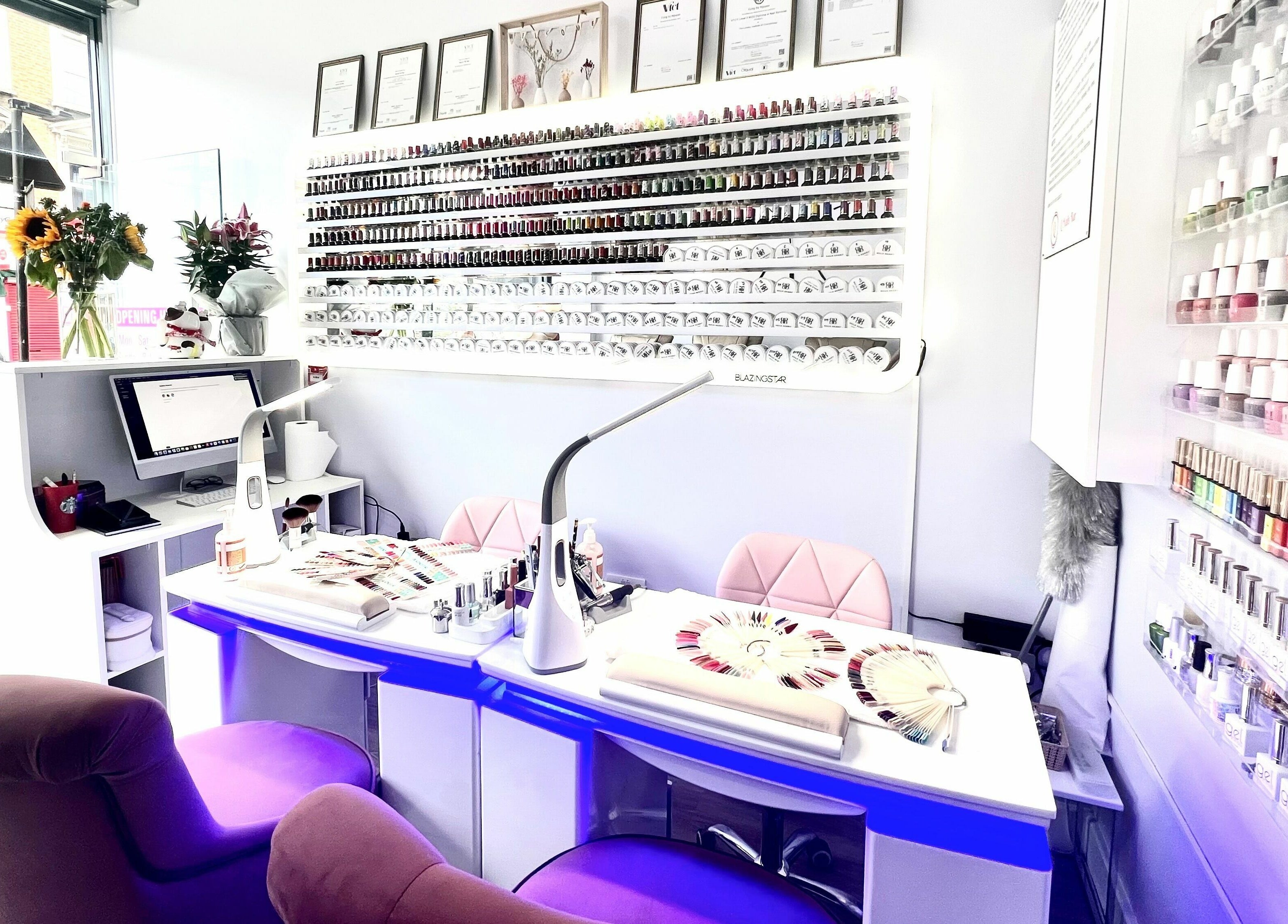 Interior of Q Nail Bar in London, England, GB showcasing nail polish display and manicure stations.