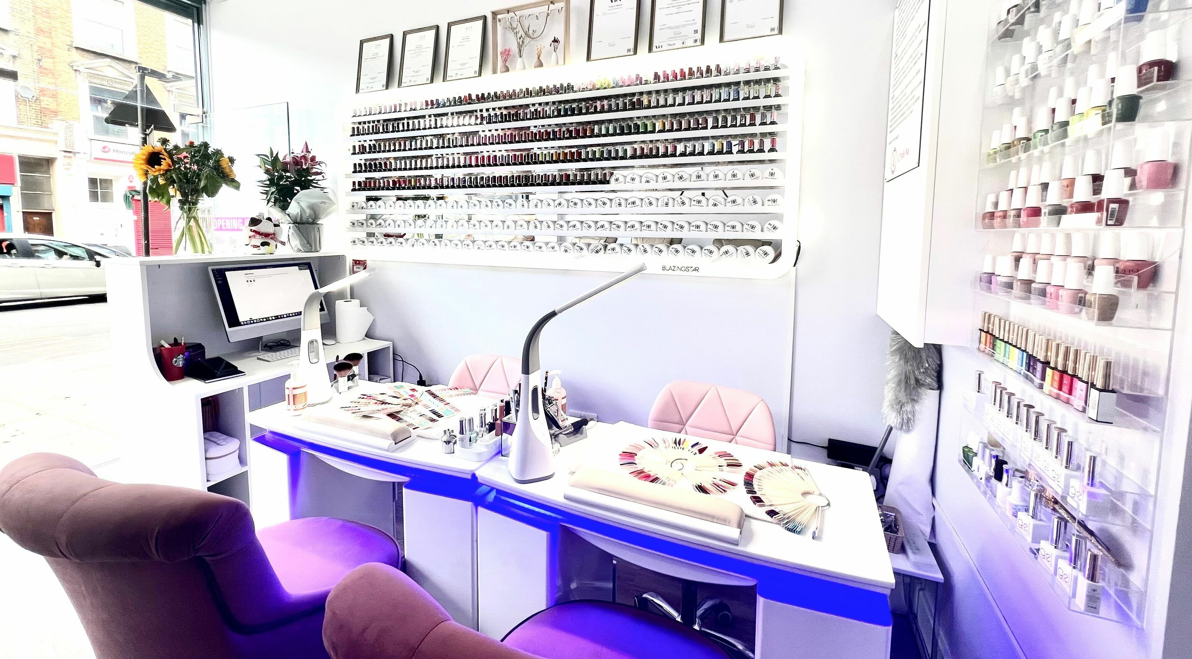 Interior of Q Nail Bar in London, England, GB showcasing nail polish display and manicure stations.